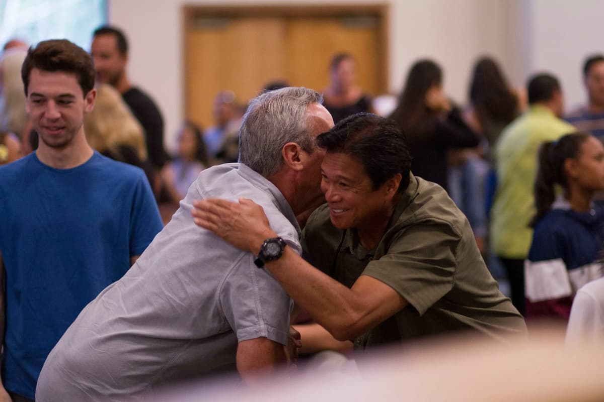 two middle aged men hugging