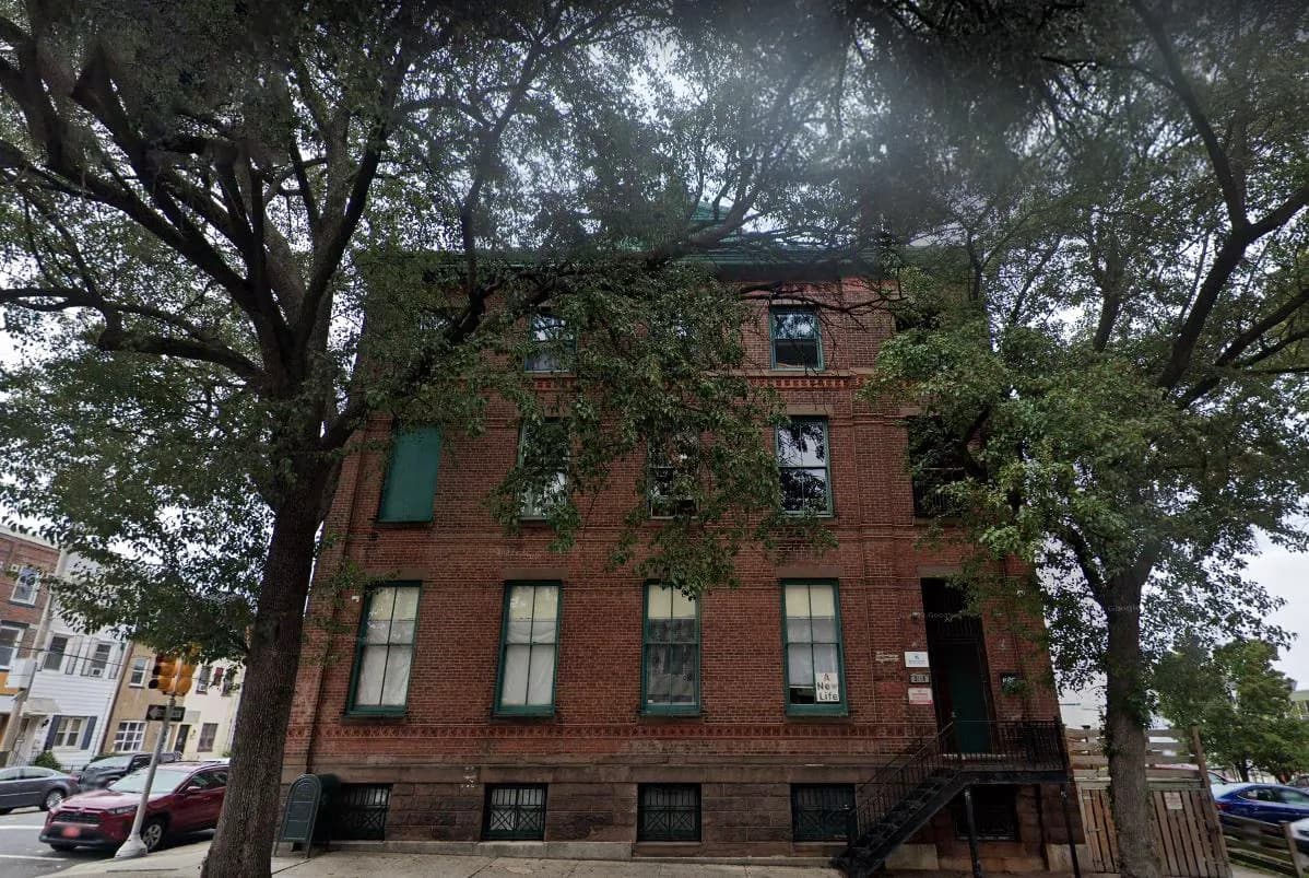 a brick building with trees in the background