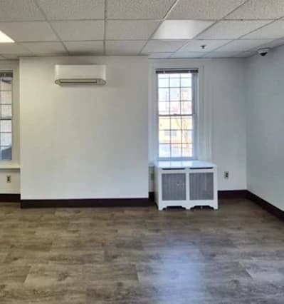 a room with a wood floor and a white cabinet