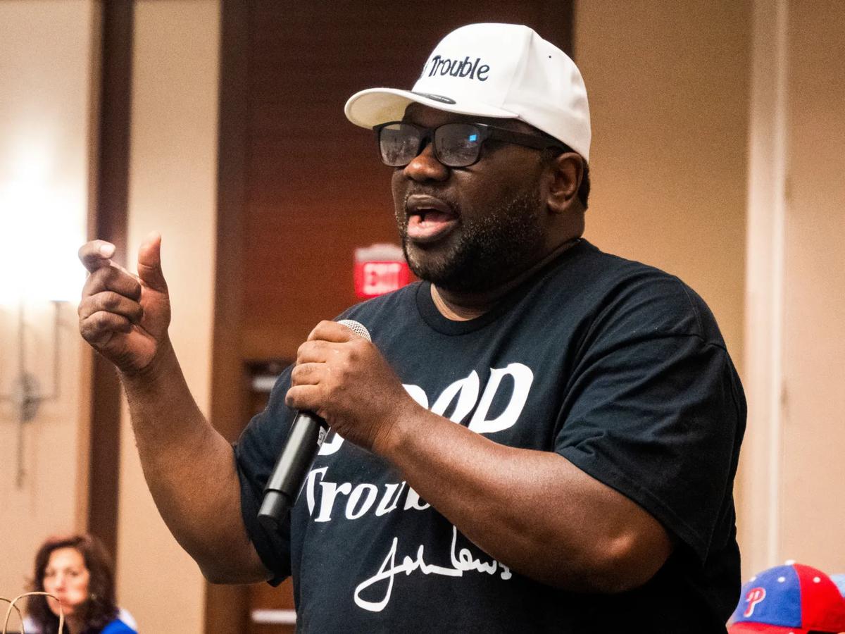 a man wearing a hat and holding a microphone