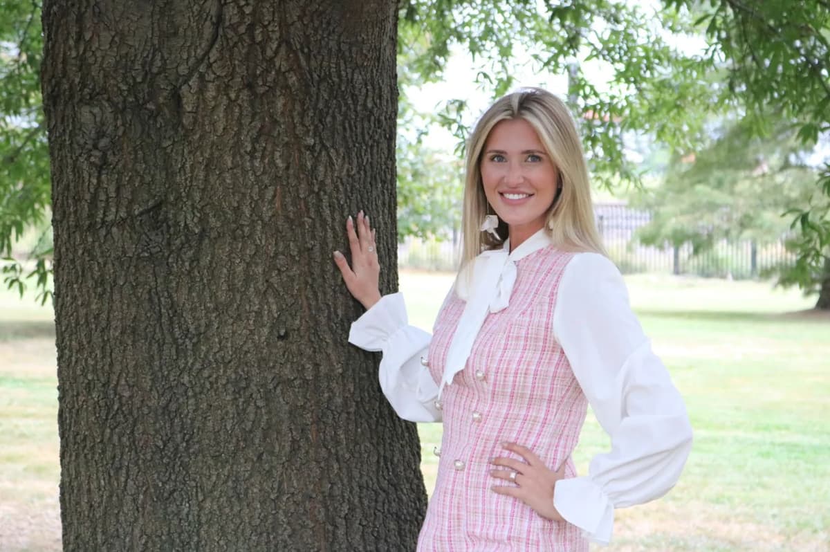 a woman standing next to a tree