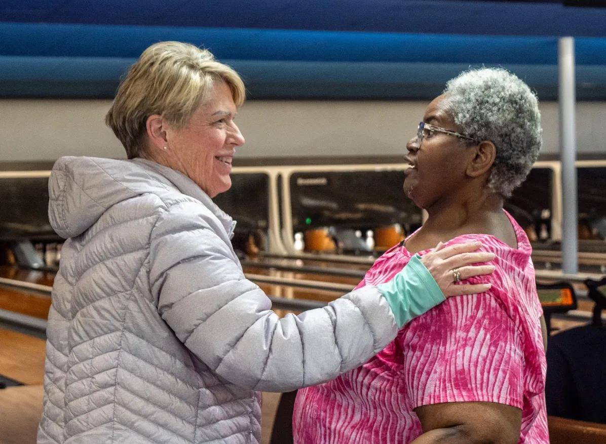 a woman holding another woman's shoulder