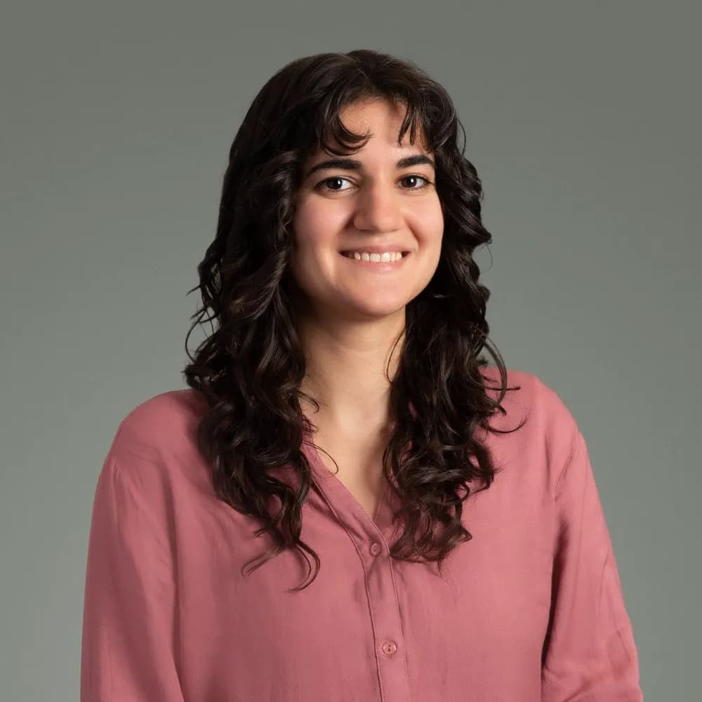 Andrea Boffice, Facilitator and Content Development Specialist, wearing a pink blouse and smiling with long dark hair.