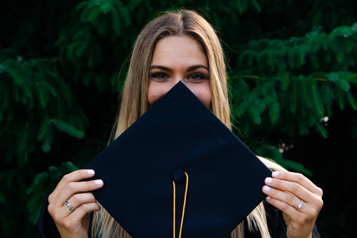 Young woman holding graduation cap after completing internship at Mental Health Partnerships