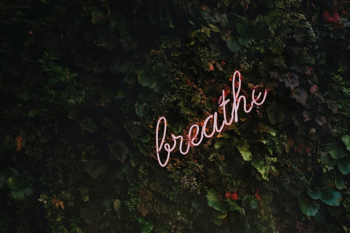 Woman practicing deep breathing outdoors for Stress Awareness Month relaxation tips