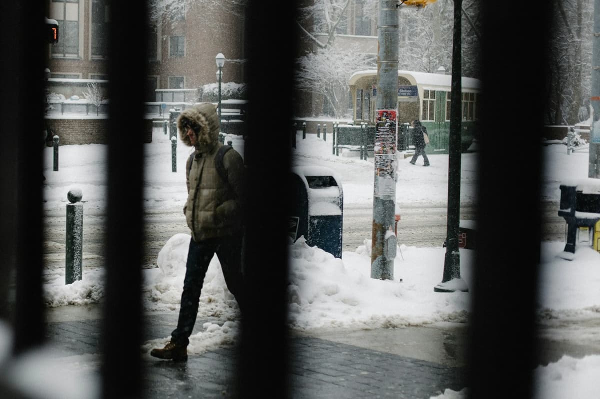 Homeless individual bundled for winter, illustrating a call to compassion and support