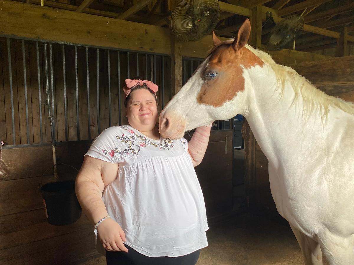 Woman bonding with a horse during an equine therapy session supporting mental health recovery